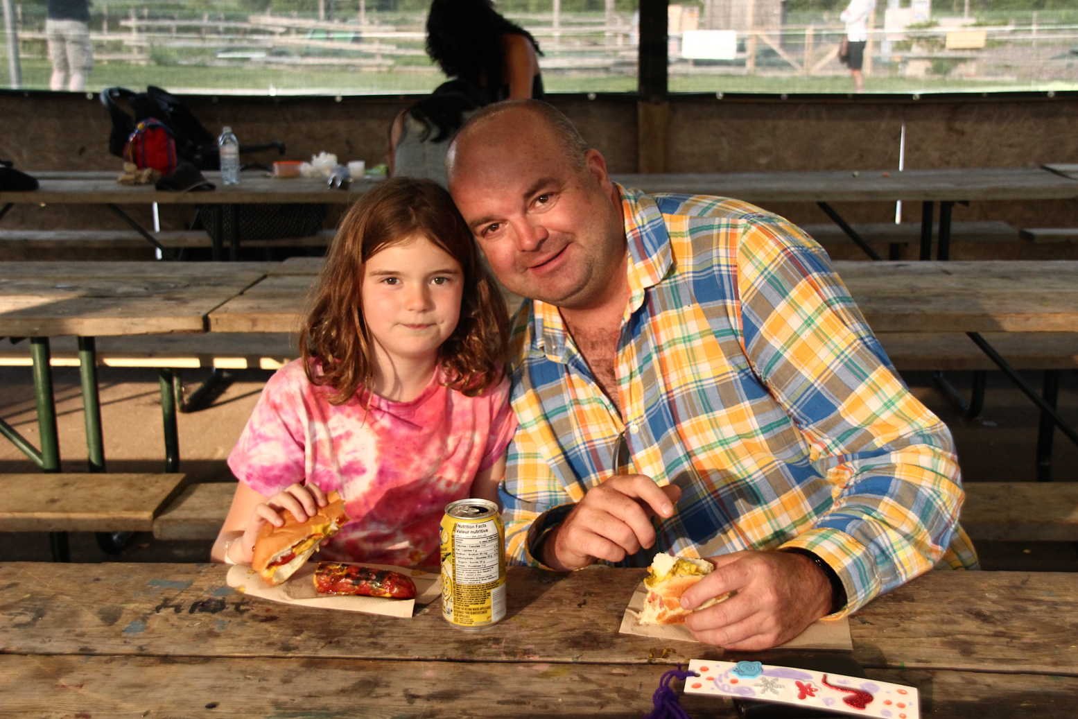 A father and daughter enjoy a hot dog together at Camp Robin Hood during one of our open house events where parents can see why kids think this is the best camp in the world!