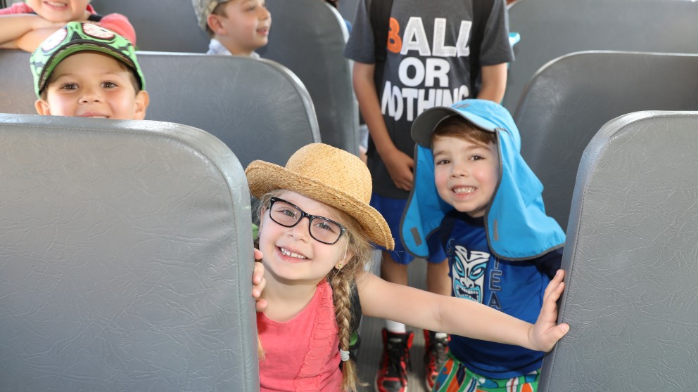 Campers smile on the camp bus