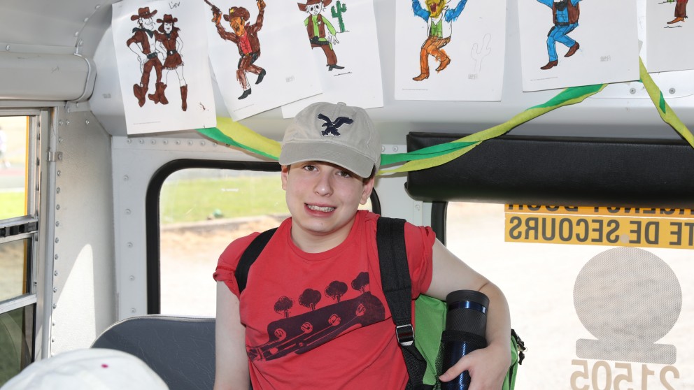 A Senior camper showing off the bus decorations after arriving at camp