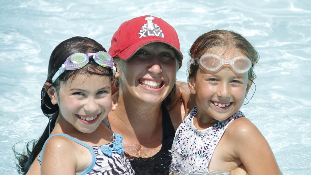 Intermediate girls having a blast with their counsellor in the swimming pool at camp!