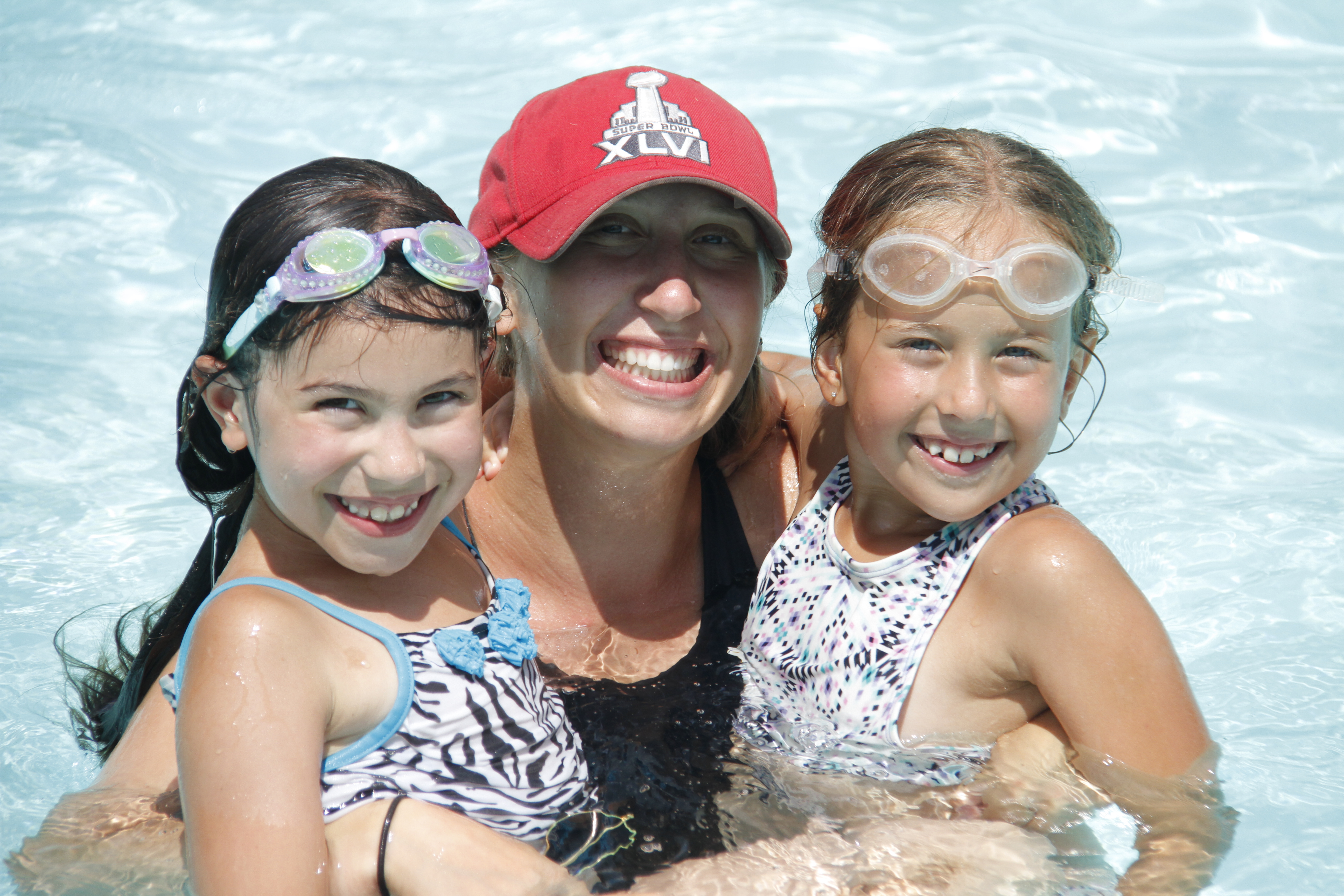 Intermediate girls having a blast with their counsellor in the swimming pool at camp!