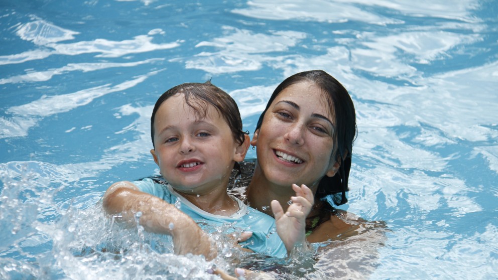 One of our highly trained swimming instructors helps a young camper learn how to swim.